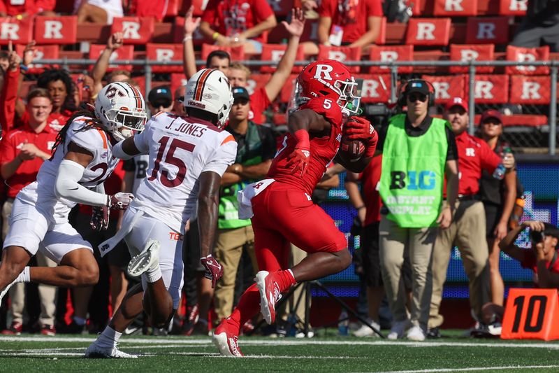 Sep 16, 2023; Piscataway, New Jersey, USA; Rutgers Scarlet Knights running back Kyle Monangai (5) scores a rushing touchdown during the first half as Virginia Tech Hokies safety Jaylen Jones (15) pursues at SHI Stadium. Mandatory Credit: Vincent Carchietta-USA TODAY Sports