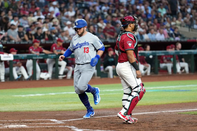 Apr 29, 2024; Phoenix, Arizona, USA; Los Angeles Dodgers third base Max Muncy (13) scores a run in front of Arizona Diamondbacks catcher Gabriel Moreno (14) during the second inning at Chase Field. Mandatory Credit: Joe Camporeale-USA TODAY Sports