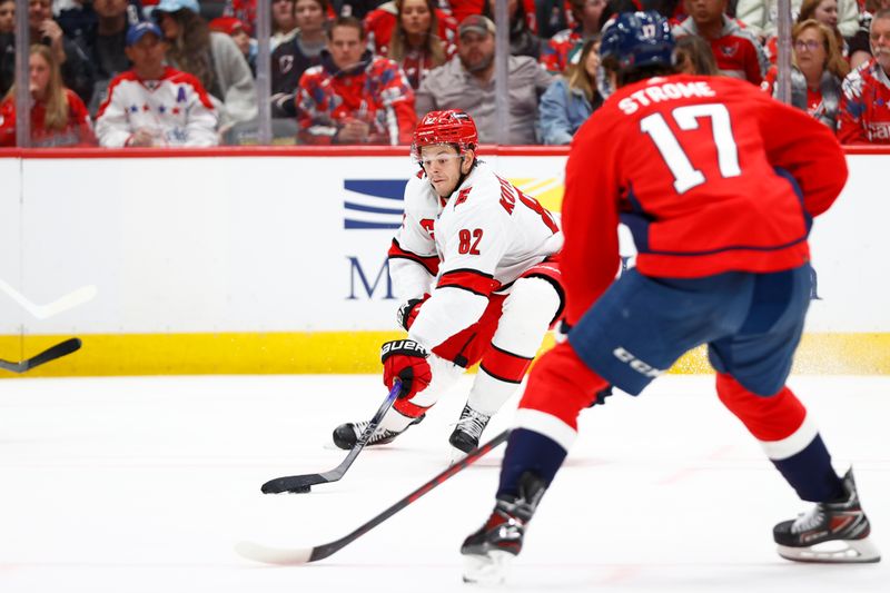 Mar 22, 2024; Washington, District of Columbia, USA; Carolina Hurricanes center Jesperi Kotkaniemi (82) reaches for the puck in front of Washington Capitals center Dylan Strome (17) during the second period at Capital One Arena. Mandatory Credit: Amber Searls-USA TODAY Sports