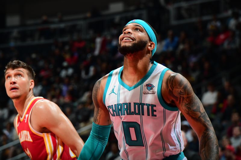 ATLANTA, GA - APRIL 10: Miles Bridges #0 of the Charlotte Hornets boxes out against Bogdan Bogdanovic #13 of the Atlanta Hawks during the game on April 10, 2024 at State Farm Arena in Atlanta, Georgia.  NOTE TO USER: User expressly acknowledges and agrees that, by downloading and/or using this Photograph, user is consenting to the terms and conditions of the Getty Images License Agreement. Mandatory Copyright Notice: Copyright 2024 NBAE (Photo by Scott Cunningham/NBAE via Getty Images)