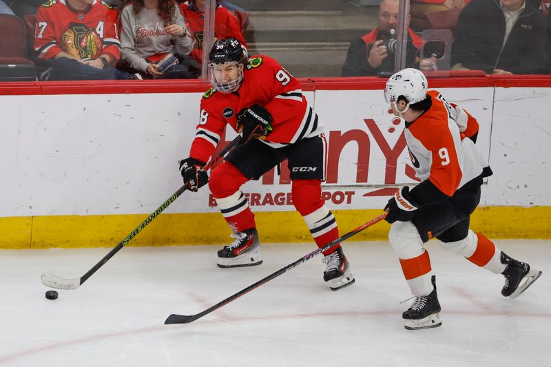 Feb 21, 2024; Chicago, Illinois, USA; Chicago Blackhawks center Connor Bedard (98) passes the puck against Philadelphia Flyers defenseman Jamie Drysdale (9) during the second period at United Center. Mandatory Credit: Kamil Krzaczynski-USA TODAY Sports