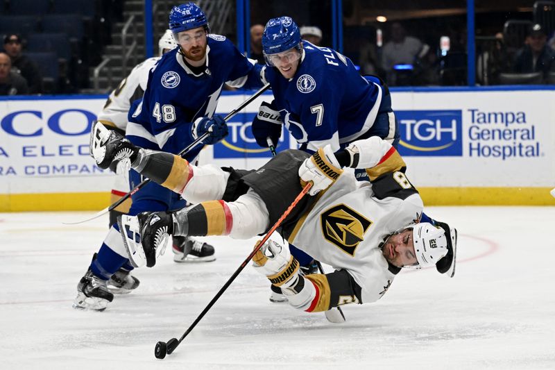 Dec 21, 2023; Tampa, Florida, USA; Las Vegas Golden Knights left wing William Carrier (28) attempts to gain control of the puck in the second period against the Tampa Bay Lightning at Amalie Arena. Mandatory Credit: Jonathan Dyer-USA TODAY Sports