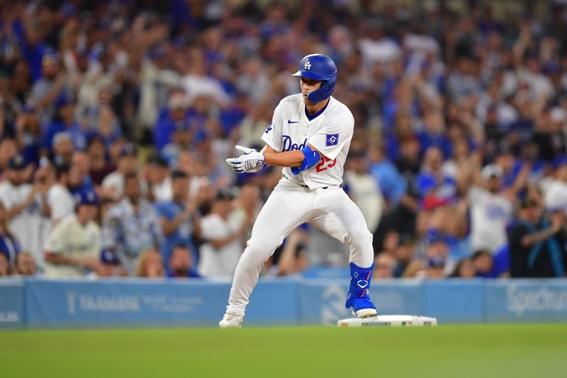 Aug 27, 2024; Los Angeles, California, USA; Los Angeles Dodgers center fielder Tommy Edman (25) reaches third on a triple against the Baltimore Orioles during the second inning at Dodger Stadium. Mandatory Credit: Gary A. Vasquez-USA TODAY Sports