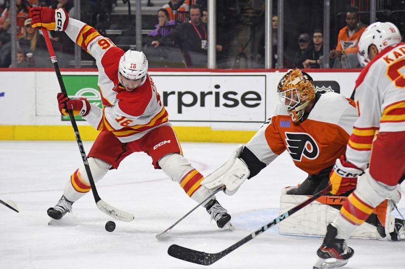 Mar 4, 2025; Philadelphia, Pennsylvania, USA; Calgary Flames center Morgan Frost (16) and Philadelphia Flyers goaltender Ivan Fedotov (82) battle for the puck during the second period at Wells Fargo Center. Mandatory Credit: Eric Hartline-Imagn Images