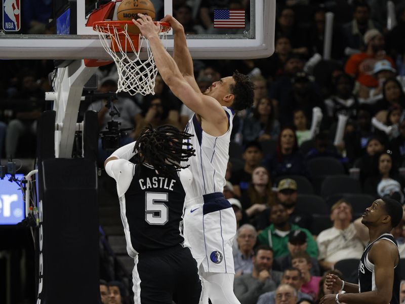 SAN ANTONIO, TX - MARCH 10:  Dwight Powell #7 of the Dallas Mavericks dunks over Stephon Castle #5 of the San Antonio Spurs in the first half at Frost Bank Center on March 10, 2025 in San Antonio, Texas. NOTE TO USER: User expressly acknowledges and agrees that, by downloading and or using this photograph, User is consenting to terms and conditions of the Getty Images License Agreement. (Photo by Ronald Cortes/Getty Images)