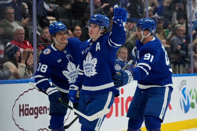 Nov 8, 2024; Toronto, Ontario, CAN; Toronto Maple Leafs forward William Nylander (88) and  forward John Tavares (91) celebrate a goal by forward Mitch Marner (16) during the first period against the Detroit Red Wings at Scotiabank Arena. Mandatory Credit: John E. Sokolowski-Imagn Images