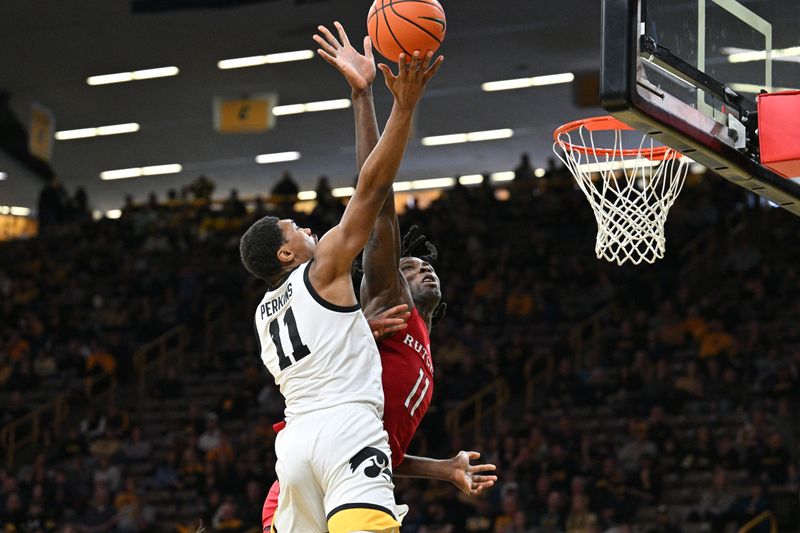 Jan 6, 2024; Iowa City, Iowa, USA; Iowa Hawkeyes guard Tony Perkins (11) goes to the basket as Rutgers Scarlet Knights center Clifford Omoruyi (11) defends during the second half at Carver-Hawkeye Arena. Mandatory Credit: Jeffrey Becker-USA TODAY Sports