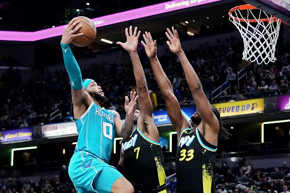 INDIANAPOLIS, INDIANA - DECEMBER 20: Miles Bridges #0 of the Charlotte Hornets goes for a layup while Buddy Hield #7 and Myles Turner #33 of the Indiana Pacers defend in the third quarter at Gainbridge Fieldhouse on December 20, 2023 in Indianapolis, Indiana. NOTE TO USER: User expressly acknowledges and agrees that, by downloading and or using this photograph, User is consenting to the terms and conditions of the Getty Images License Agreement. (Photo by Dylan Buell/Getty Images)