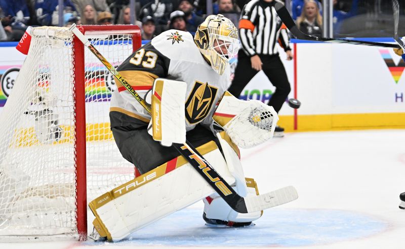 Feb 27, 2024; Toronto, Ontario, CAN;  Vegas Golden Knights goalie Adin Hill (33) makes a save against the Toronto Maple Leafs in the first period at Scotiabank Arena. Mandatory Credit: Dan Hamilton-USA TODAY Sports