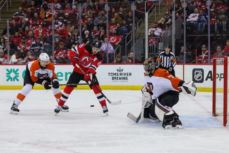 Jan 18, 2025; Newark, New Jersey, USA; New Jersey Devils center Jack Hughes (86) tries to tip the puck in front of Philadelphia Flyers goaltender Samuel Ersson (33) during the second period at Prudential Center. Mandatory Credit: Ed Mulholland-Imagn Images