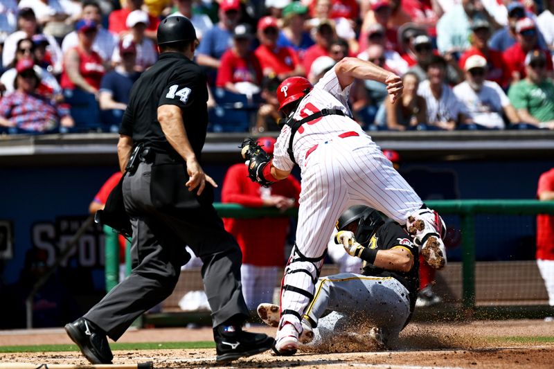 Mar 18, 2024; Clearwater, Florida, USA;Philadelphia Phillies catcher J.T. Realmuto (10) attempts to tag out  Pittsburgh Pirates second baseman Jared Triolo (19) in the second inning of the spring training game at BayCare Ballpark. Mandatory Credit: Jonathan Dyer-USA TODAY Sports