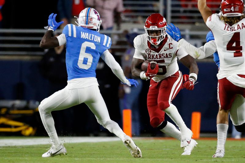 Oct 7, 2023; Oxford, Mississippi, USA; Arkansas Razorbacks running back Raheim Sanders (5) runs after a catch as Mississippi Rebels defensive back Zamari Walton (6) defends during the first half at Vaught-Hemingway Stadium. Mandatory Credit: Petre Thomas-USA TODAY Sports