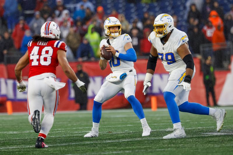 Los Angeles Chargers quarterback Justin Herbert (10) prepares to make a pass while protected by offensive tackle Trey Pipkins III (79) from New England Patriots linebacker Jahlani Tavai (48) during the second half of an NFL football game on Sunday, Dec. 3, 2023, in Foxborough, Mass. (AP Photo/Greg M. Cooper)