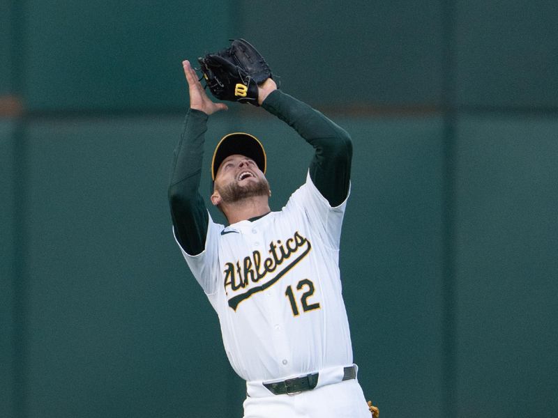 Jun 21, 2024; Oakland, California, USA; Oakland Athletics shortstop Max Schuemann (12) catches the ball against the Minnesota Twins during the fifth inning at Oakland-Alameda County Coliseum. Mandatory Credit: Stan Szeto-USA TODAY Sports