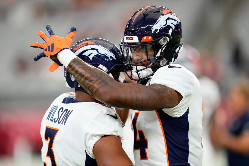 Denver Broncos quarterback Russell Wilson, left, hugs wide receiver Courtland Sutton before an NFL preseason football game against the Arizona Cardinals in Glendale, Ariz., Friday, Aug. 11, 2023. (AP Photo/Ross D. Franklin)