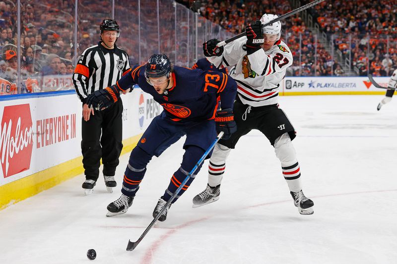 Jan 25, 2024; Edmonton, Alberta, CAN; Edmonton Oilers defensemen Vincent Desharnais (73) and Chicago Blackhawks forward Lukas Reichel (27) battle for a loose puck during the second period at Rogers Place. Mandatory Credit: Perry Nelson-USA TODAY Sports