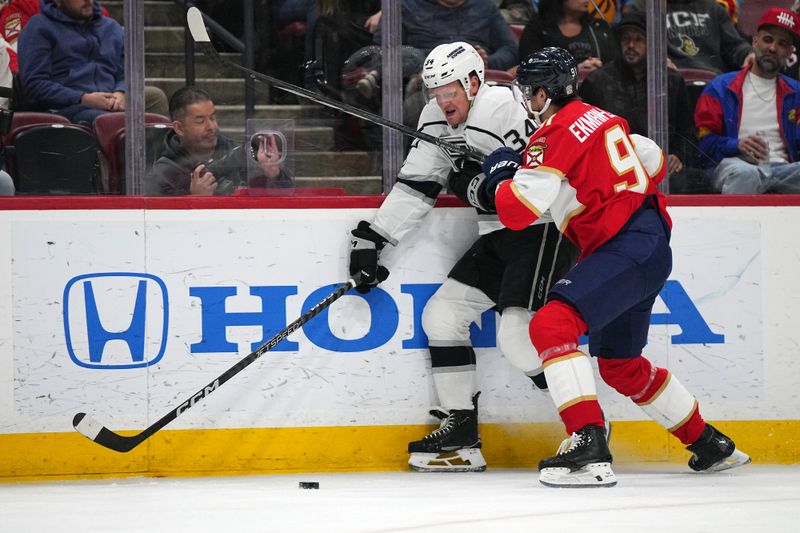 Jan 11, 2024; Sunrise, Florida, USA; Florida Panthers defenseman Oliver Ekman-Larsson (91) checks Los Angeles Kings right wing Arthur Kaliyev (34) off the puck during the first period at Amerant Bank Arena. Mandatory Credit: Jasen Vinlove-USA TODAY Sports