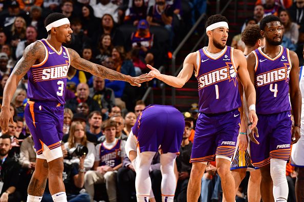 PHOENIX, AZ - DECEMBER 12: Bradley Beal  #3 and Devin Booker #1 of the Phoenix Suns high five during the game against the Golden State Warriors on December 12, 2023 at Footprint Center in Phoenix, Arizona. NOTE TO USER: User expressly acknowledges and agrees that, by downloading and or using this photograph, user is consenting to the terms and conditions of the Getty Images License Agreement. Mandatory Copyright Notice: Copyright 2023 NBAE (Photo by Barry Gossage/NBAE via Getty Images)