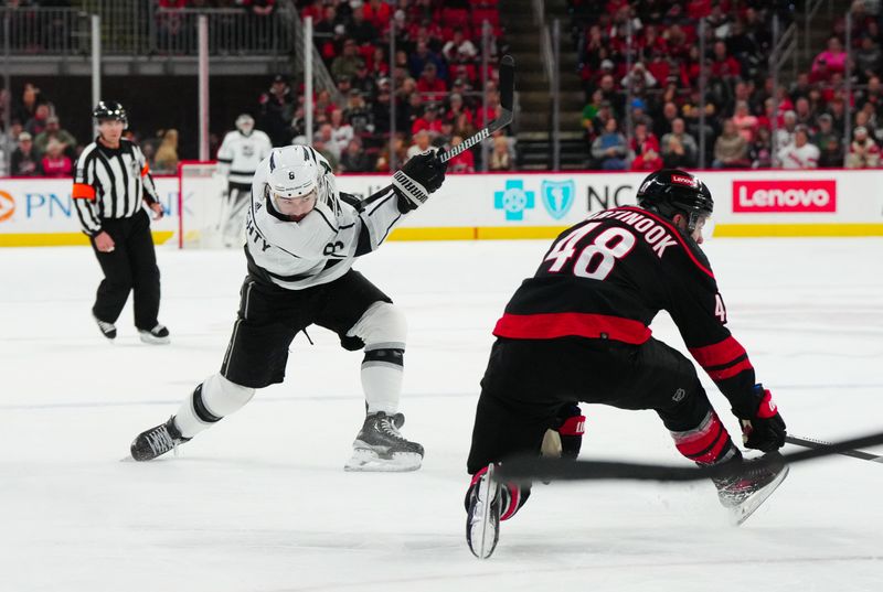 Jan 15, 2024; Raleigh, North Carolina, USA; Los Angeles Kings defenseman Drew Doughty (8) takes a shot past Carolina Hurricanes left wing Jordan Martinook (48) during the second period at PNC Arena. Mandatory Credit: James Guillory-USA TODAY Sports