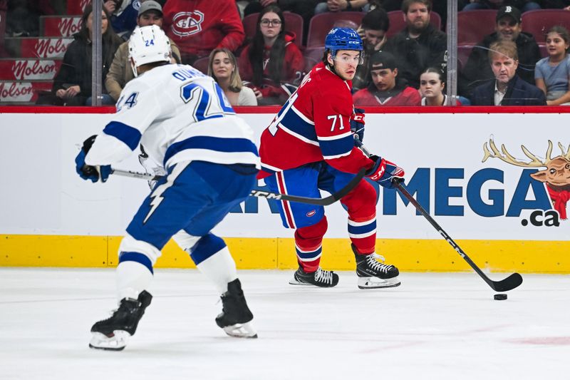 Apr 4, 2024; Montreal, Quebec, CAN; Montreal Canadiens center Jake Evans (71) plays the puck against Tampa Bay Lightning defenseman Mathew Dumba (24) during the first period at Bell Centre. Mandatory Credit: David Kirouac-USA TODAY Sports