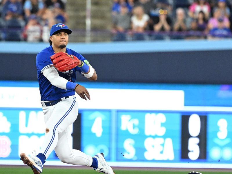 Aug 26, 2023; Toronto, Ontario, CAN;  Toronto Blue Jays shortstop Santiago Espinal (5) throws to first base for a double play against Cleveland Guardians center fielder Myles Straw (7) in the seventh inning at Rogers Centre. Mandatory Credit: Dan Hamilton-USA TODAY Sports