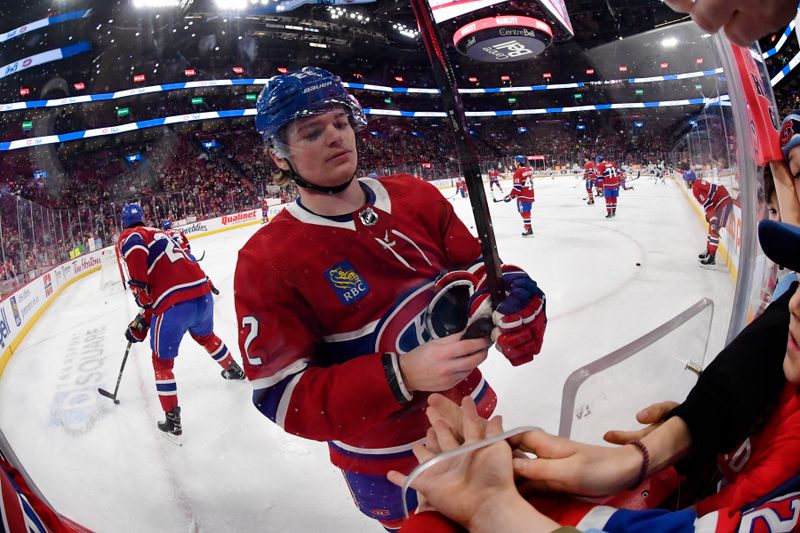 Jan 13, 2024; Montreal, Quebec, CAN; Montreal Canadiens forward Cole Caufield (22) tries to give a puck to a fan during the warmup period before the game against the Edmonton Oilers at the Bell Centre. Mandatory Credit: Eric Bolte-USA TODAY Sports