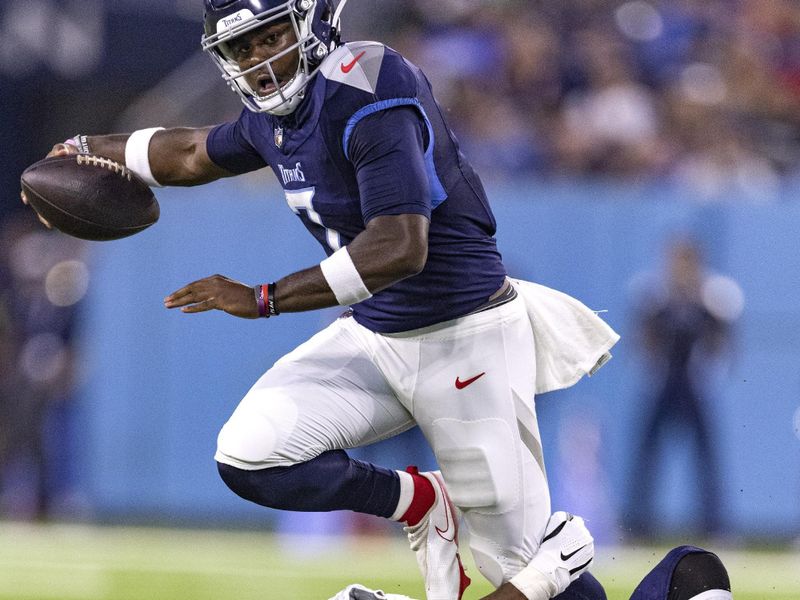 Tennessee Titans quarterback Malik Willis (7) tries to escape the grasp of New England Patriots linebacker Ronnie Perkins (51) during their NFL football game Friday, Aug. 25, 2023, in Nashville, Tenn. (AP Photo/Wade Payne)