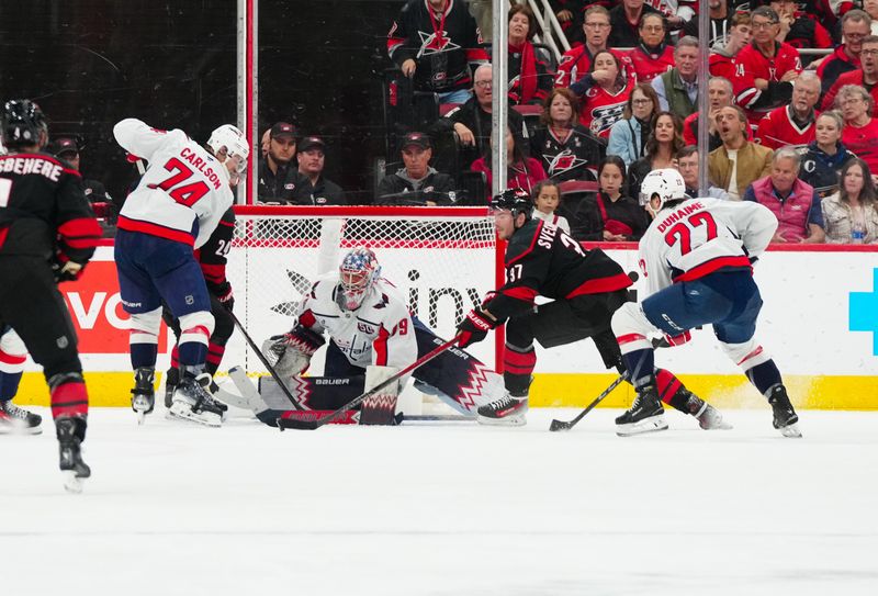 Nov 3, 2024; Raleigh, North Carolina, USA;  Carolina Hurricanes right wing Andrei Svechnikov (37) goes after the puck against Washington Capitals goaltender Charlie Lindgren (79 right wing Brandon Duhaime (22) and defenseman John Carlson (74) during the second period at Lenovo Center. Mandatory Credit: James Guillory-Imagn Images