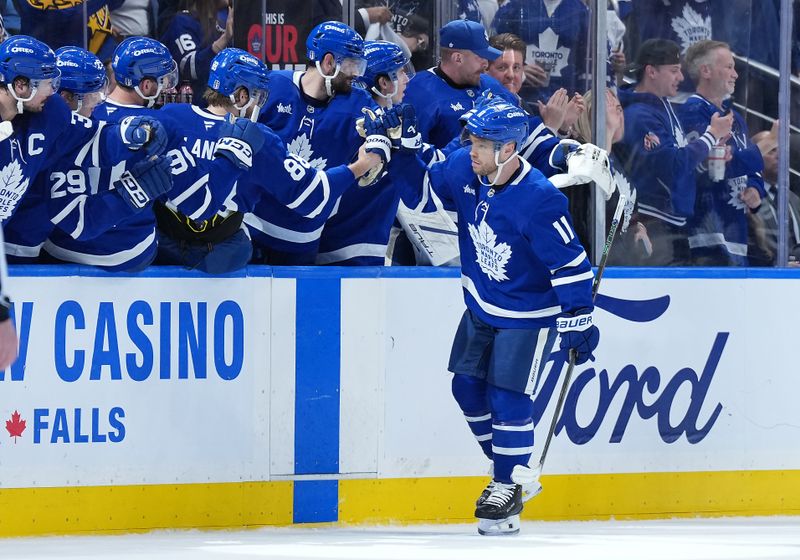 May 7, 2025; Toronto, Ontario, CAN; Toronto Maple Leafs center Max Domi (11) celebrates at the bench after scoring a goal against the Florida Panthers during the second period in game two of the second round of the 2025 Stanley Cup Playoffs at Scotiabank Arena. Mandatory Credit: Nick Turchiaro-Imagn Images