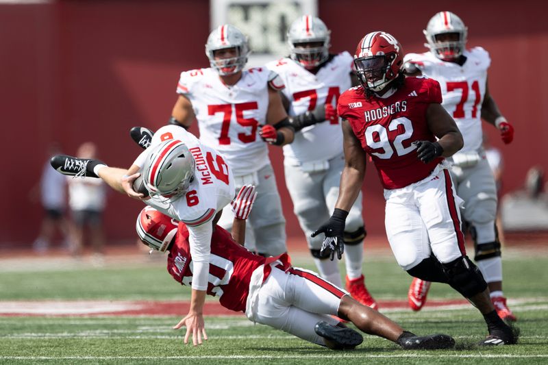 Sep 2, 2023; Bloomington, Indiana, USA; Ohio State Buckeyes quarterback Kyle McCord (6) is tackled by Indiana Hoosiers defensive back Louis Moore (20) during the first quarter at Memorial Stadium. Mandatory Credit: Marc Lebryk-USA TODAY Sports