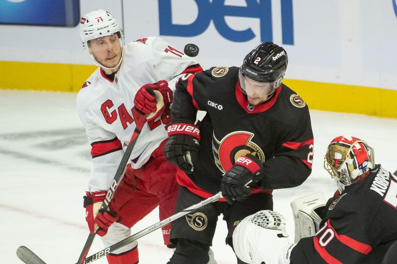 Dec 12, 2023; Ottawa, Ontario, CAN; Carolina Hurricanes right wing Jesper Fast (21) and Ottawa Senators defenseman Artem Zub (2) jostle around the puck in the third period at the Canadian Tire Centre. Mandatory Credit: Marc DesRosiers-USA TODAY Sports.