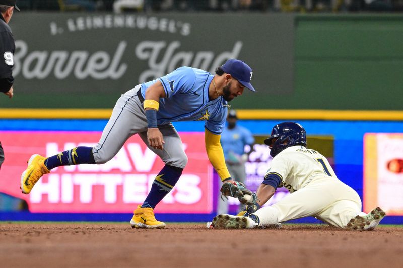 Apr 30, 2024; Milwaukee, Wisconsin, USA;  Milwaukee Brewers right fielder Jackson Chourio (11) steals second base before a tag by Tampa Bay Rays shortstop Jose Caballero (7) in the second inning at American Family Field. Mandatory Credit: Benny Sieu-USA TODAY Sports