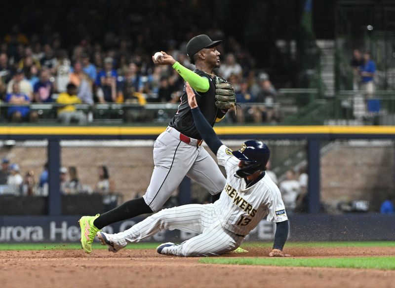 Sep 21, 2024; Milwaukee, Wisconsin, USA; Milwaukee Brewers catcher Eric Haase (13) attempts to break up the double play by Arizona Diamondbacks shortstop Geraldo Perdomo (2) in the third inning at American Family Field. Mandatory Credit: Michael McLoone-Imagn Images