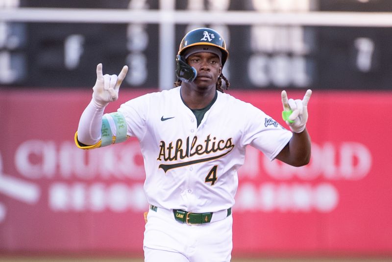 Jul 2, 2024; Oakland, California, USA; Oakland Athletics outfielder Lawrence Butler (4) motions to his team mates after hitting a home run against the Los Angeles Angels during the fourth inning at Oakland-Alameda County Coliseum. Mandatory Credit: Ed Szczepanski-USA TODAY Sports