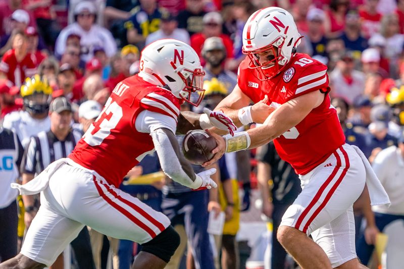 Sep 30, 2023; Lincoln, Nebraska, USA; Nebraska Cornhuskers quarterback Heinrich Haarberg (10) hands the ball off to running back Anthony Grant (23) against the Michigan Wolverines during the first quarter at Memorial Stadium. Mandatory Credit: Dylan Widger-USA TODAY Sports