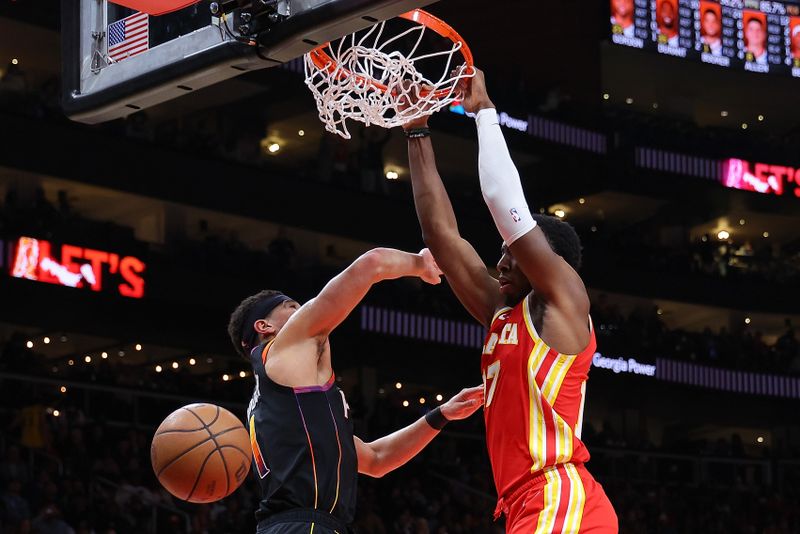 ATLANTA, GEORGIA - FEBRUARY 02:  Onyeka Okongwu #17 of the Atlanta Hawks dunks against Devin Booker #1 of the Phoenix Suns during the fourth quarter at State Farm Arena on February 02, 2024 in Atlanta, Georgia.  NOTE TO USER: User expressly acknowledges and agrees that, by downloading and/or using this photograph, user is consenting to the terms and conditions of the Getty Images License Agreement.  (Photo by Kevin C. Cox/Getty Images)