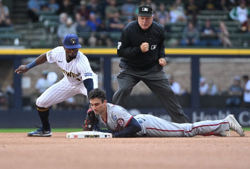 Sep 17, 2023; Milwaukee, Wisconsin, USA; Washington Nationals catcher Drew Millas (81) slides in safely ahead of the tag by Milwaukee Brewers second baseman Andruw Monasterio (14) in the eighth inning at American Family Field. Mandatory Credit: Michael McLoone-USA TODAY Sports