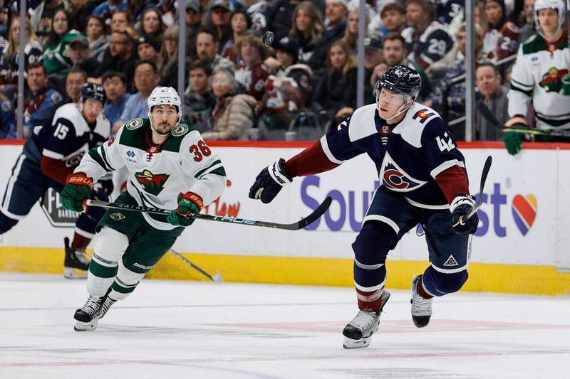 Mar 8, 2024; Denver, Colorado, USA; Colorado Avalanche defenseman Josh Manson (42) and Minnesota Wild right wing Mats Zuccarello (36) watch a loose puck in the air in the third period at Ball Arena. Mandatory Credit: Isaiah J. Downing-USA TODAY Sports