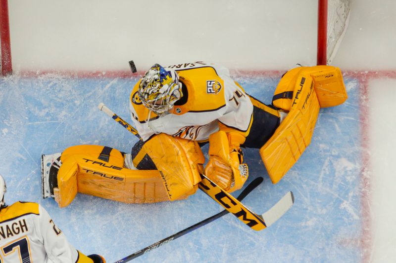 Dec 29, 2023; Detroit, Michigan, USA; The pucks slips past Nashville Predators goaltender Juuse Saros (74) during the game between the Detroit Red Wings and the Nashville Predators at Little Caesars Arena. Mandatory Credit: Brian Bradshaw Sevald-USA TODAY Sports