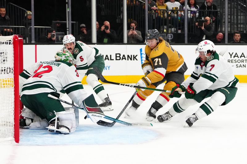 Feb 12, 2024; Las Vegas, Nevada, USA; Minnesota Wild goaltender Filip Gustavsson (32) makes a save against Vegas Golden Knights center William Karlsson (71) as he splits between Wild defenseman Jake Middleton (5) and defenseman Brock Faber (7) during the third period at T-Mobile Arena. Mandatory Credit: Stephen R. Sylvanie-USA TODAY Sports