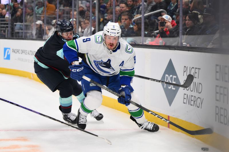 Feb 22, 2024; Seattle, Washington, USA; Vancouver Canucks center J.T. Miller (9) plays the puck while defended by Seattle Kraken defenseman Will Borgen (3) during the first period at Climate Pledge Arena. Mandatory Credit: Steven Bisig-USA TODAY Sports