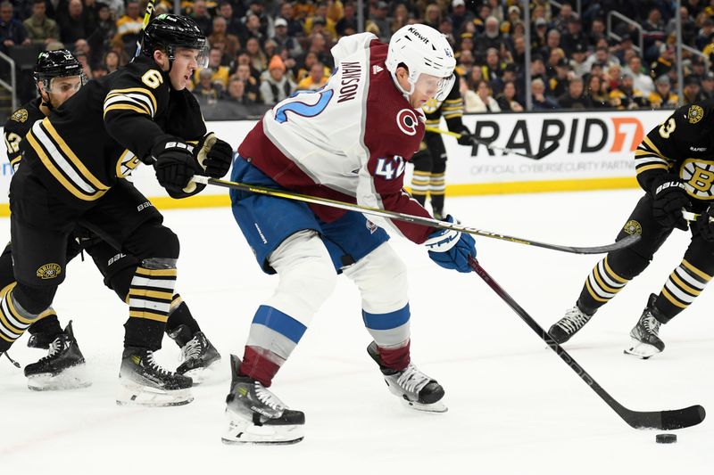 Jan 18, 2024; Boston, Massachusetts, USA; Colorado Avalanche defenseman Josh Manson (42) controls the puck while Boston Bruins defenseman Mason Lohrei (6) defends during the second period at TD Garden. Mandatory Credit: Bob DeChiara-USA TODAY Sports