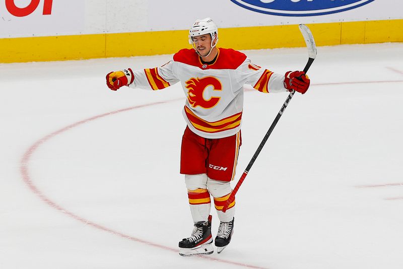Sep 21, 2025; Edmonton, Alberta, CAN; Calgary Flames forward Morgan Frost (16) celebrates scoring the winning goal during overtime against the Edmonton Oilers at Rogers Place. Mandatory Credit: Perry Nelson-Imagn Images
