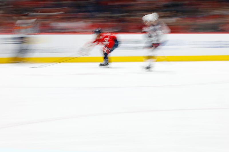 Nov 2, 2024; Washington, District of Columbia, USA; Washington Capitals right wing Brandon Duhaime (22) and Columbus Blue Jackets defenseman Jake Christiansen (2) chase the puck in the third period at Capital One Arena. Mandatory Credit: Geoff Burke-Imagn Images