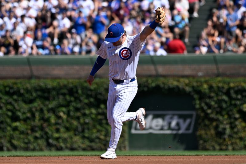 Sep 21, 2024; Chicago, Illinois, USA;  Chicago Cubs second baseman Nico Hoerner (2) points after he tags out Washington Nationals second baseman Luis García Jr. (2) on an attempted steal during the first inning at Wrigley Field. Mandatory Credit: Matt Marton-Imagn Images