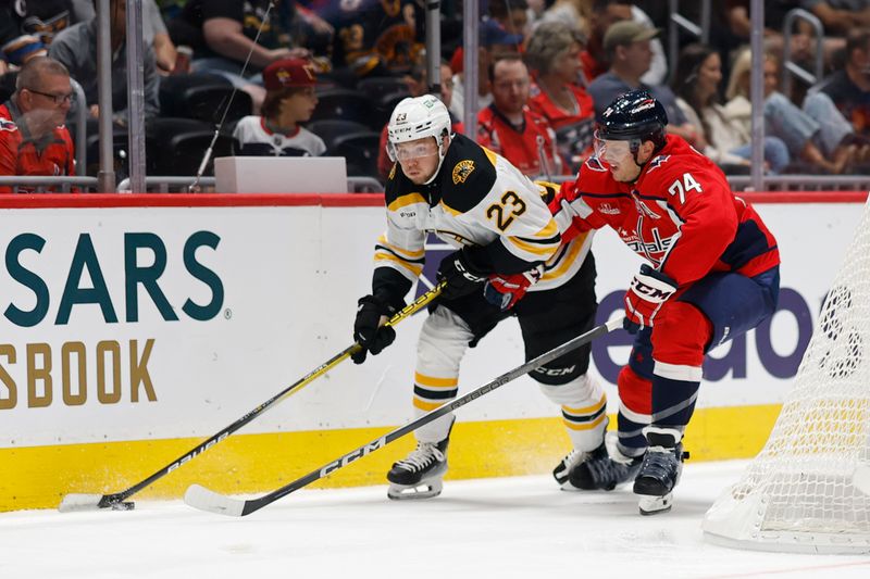 Oct 5, 2024; Washington, District of Columbia, USA; Boston Bruins right wing Fabian Lysell (23) skates with the puck as Washington Capitals defenseman John Carlson (74) defends in the second period at Capital One Arena. Mandatory Credit: Geoff Burke-Imagn Images