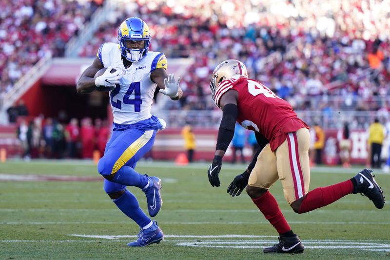 Los Angeles Rams running back Royce Freeman (24) runs against San Francisco 49ers linebacker Demetrius Flannigan-Fowles during the second half of an NFL football game in Santa Clara, Calif., Sunday, Jan. 7, 2024. (AP Photo/Loren Elliott)