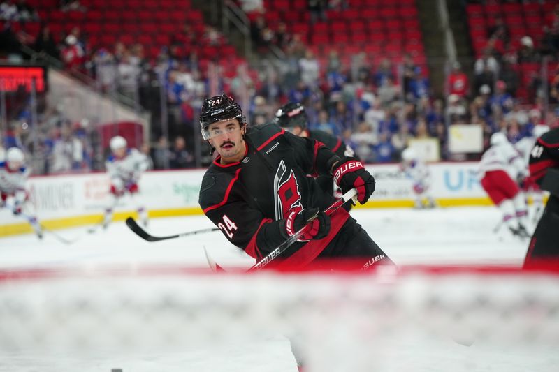 Nov 27, 2024; Raleigh, North Carolina, USA;  Carolina Hurricanes center Seth Jarvis (24) takes a shot during the warmups before the game against the New York Rangers at Lenovo Center. Mandatory Credit: James Guillory-Imagn Images