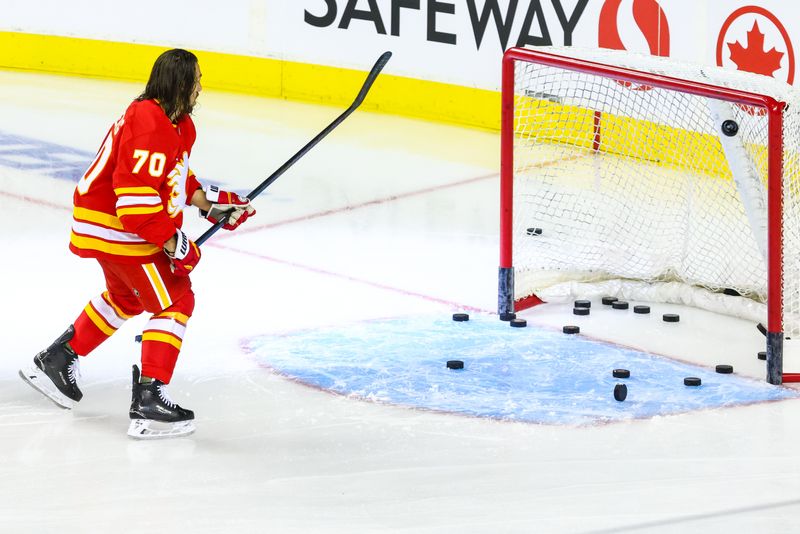 Sep 23, 2024; Calgary, Alberta, CAN; Calgary Flames left wing Ryan Lomberg (70) shoots pucks during the warmup period against the Edmonton Oilers at Scotiabank Saddledome. Mandatory Credit: Sergei Belski-Imagn Images