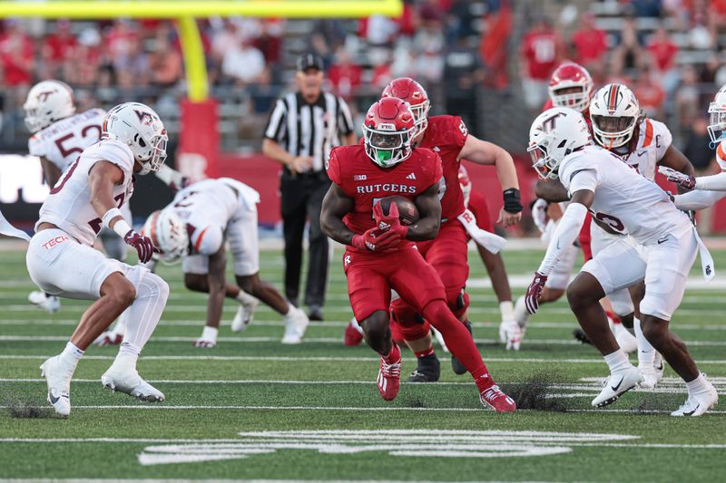 Sep 16, 2023; Piscataway, New Jersey, USA; Rutgers Scarlet Knights running back Kyle Monangai (5) carries the ball as Virginia Tech Hokies safety Caleb Woodson (20) and safety Jaylen Jones (15) pursue  during the second half at SHI Stadium. Mandatory Credit: Vincent Carchietta-USA TODAY Sports